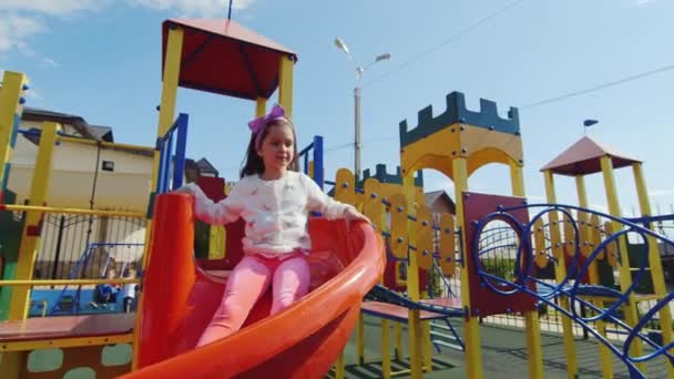 Barn glidande på en bild i Park, lilla flicka som leker på lekplatsen, barn — Stockvideo