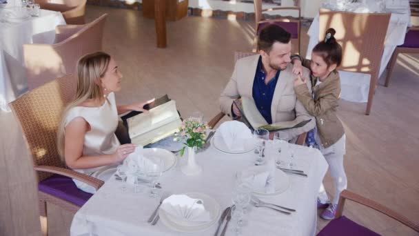 Familie bestellt Abendessen in einem Café oder Restaurant. Der Höhepunkt des Schießens — Stockvideo