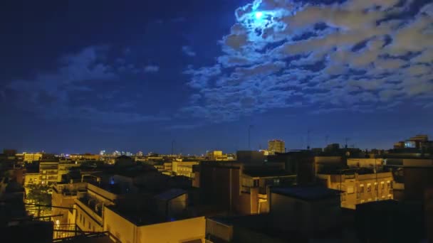 Moonrise over the city and the roofs of houses. Timelapse from evening to dawn. The sun rises over the city — Stock Video