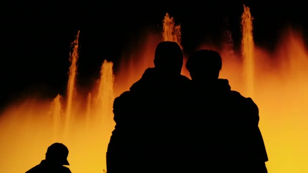 Slhouettes of unrecognizable people: who watch the show of luminous fountains. Barcelona, Spain — Stock Video