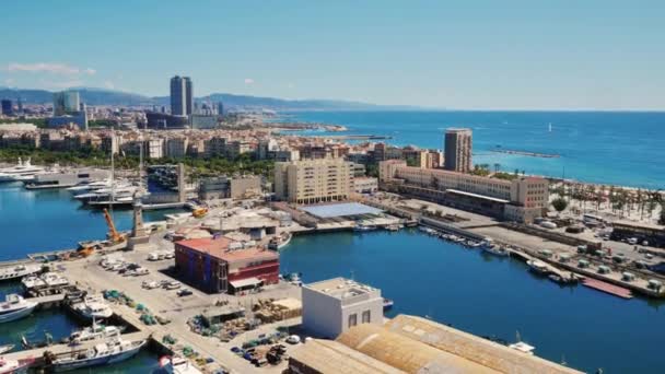 Antenne von Barcelona, mit Blick auf den Hafen und die Uferpromenade. Im Hafen gibt es Boote, Autos fahren. Port Vell — Stockvideo