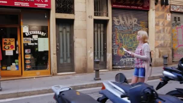 Βαρκελώνη, Ισπανία - 15 Ιουνίου 2016: Ένα κορίτσι με ένα χάρτη ή οδηγό για το περπάτημα στο δρόμο της γοτθικής συνοικίας — Αρχείο Βίντεο