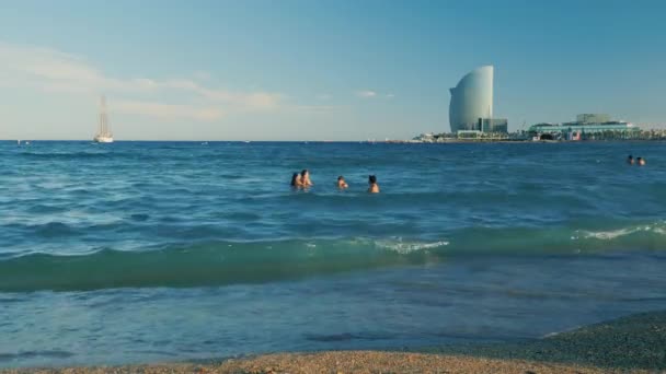 Barcelona, Španělsko - 15 červen 2016: Beach Barcelona, lidé, koupání v moři na pozadí rozpoznatelné budov města — Stock video