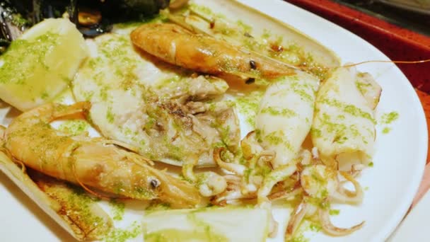 Close-up - eat seafood. On a plate the knife cuts the mollusk — Stock Video
