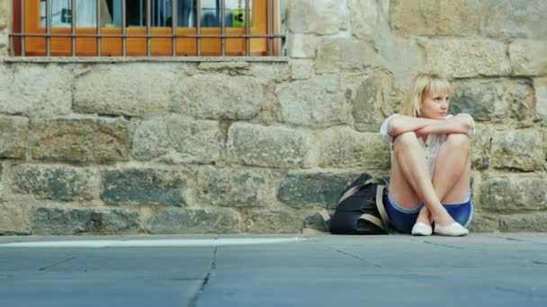 Une femme fatiguée assise dans la rue. En passant par les gens. Concept - se perdre dans une ville inconnue. Barcelone, Espagne — Video