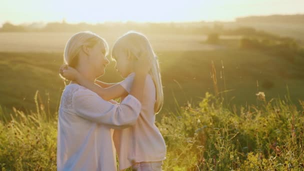 Mamãe brinca com sua filha 5 anos. No prado ao pôr-do-sol — Vídeo de Stock