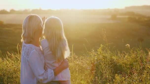 Madre e hija mirando el atardecer. Vista trasera — Vídeo de stock