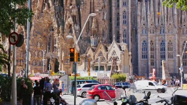 Barcelona, Spanje - 20 juni 2016: Toeristen en autoverkeer in de buurt van de beroemde Sagrada Familia — Stockvideo