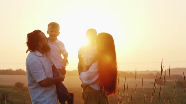 Šťastná rodina hrát s dětmi při západu slunce. Mami, táta a dvě děti