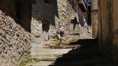 Catalonia Rupit antik şehirde boyunca kadın turist elinde harita ile yürür. İspanyol turistler arasında popüler