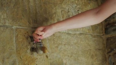 Isı yorgun bir taş duvar antik Vinçli kadın yıkar. Rupit kasaba Catalonia