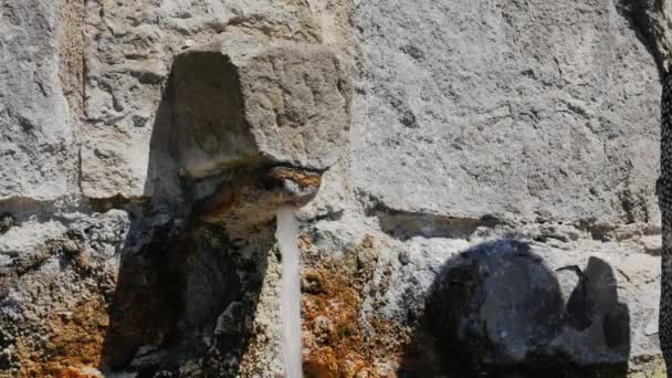 Kvinnan turist tvättar händerna av gamla sten kran. I staden Rupit, Katalonien — Stockvideo