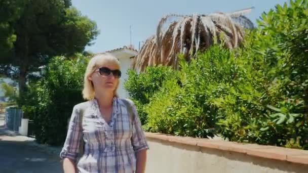 Steadicam shot: Woman tourist walking on the seaside resort — Stock Video