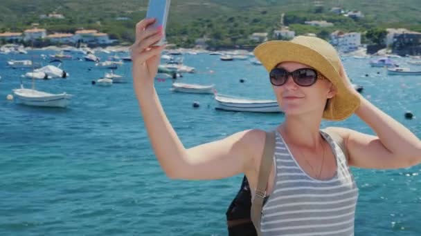 Steadicam volare intorno girato: Giovane donna fotografandosi sullo sfondo della città termale e baia con yacht. Godetevi le vostre vacanze — Video Stock