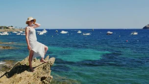 クレーン ショット: 浜辺に立って海を眺めながらの若い女性。海、ヨット、ボート、絵のような風景で — ストック動画