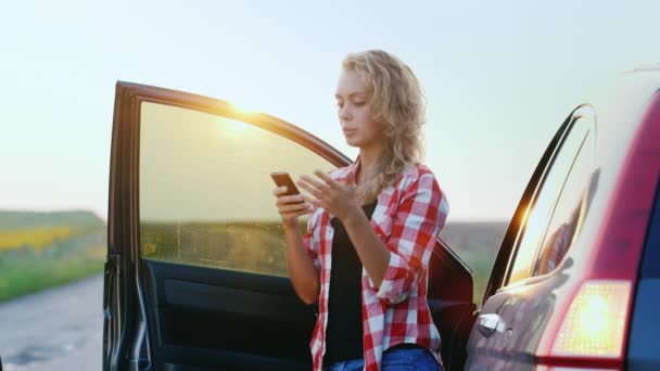 Young woman trying to get through to the emergency service. On the road, poor communication, no network — Stock Video