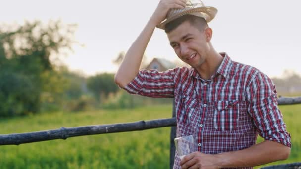 Un joven sufriendo del calor, bebiendo cerveza del vaso — Vídeo de stock