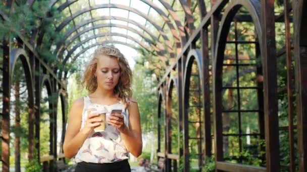 Empregos e comida em movimento. Mulher de negócios com uma xícara de café e telefone está no terraço — Vídeo de Stock