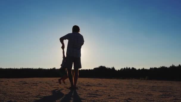 Gelukkige jeugd - een vader spelen met zijn zoon bij zonsondergang, veel cirkelen het — Stockvideo