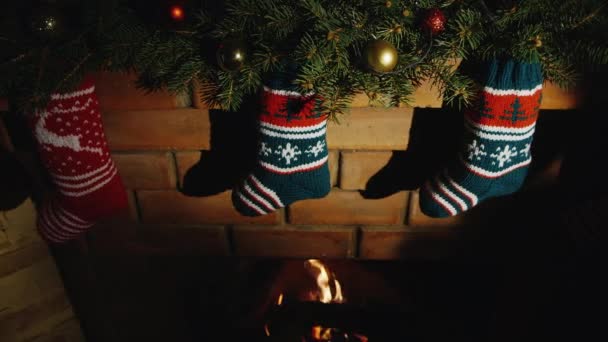 Noel hediyeleri için çorap. Yanan şöminenin asmak — Stok video