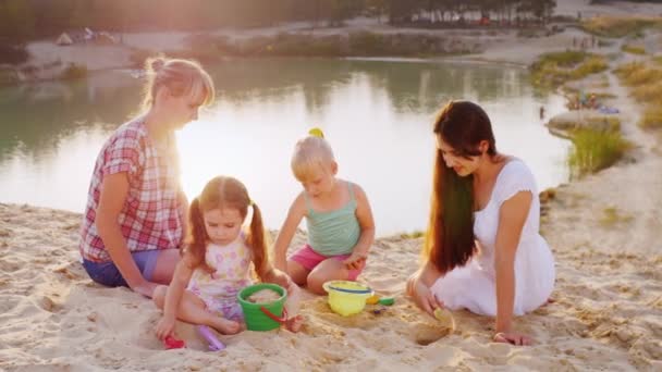 Dos madres jugando a la arena con dos hijas de 3 y 5 años — Vídeos de Stock