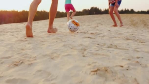 Familie voetballen. In het kader van de mens sloeg benen de bal de bal op het zand — Stockvideo