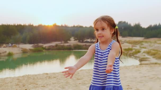 Söt flicka på tre år spelar boll, fånga en boll på stranden — Stockvideo