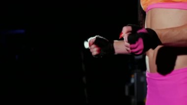 Düz bir karın ile atletik kadın eğitim önce ellerini kneads. Siyah arka plan