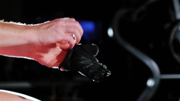 Preparation for training. Woman putting on gloves in the spotlight — Stock Video