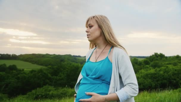 Steadicam shot: έγκυος γυναίκα που περπατά στη γραφική γέφυρα με φόντο πράσινο δάσος — Αρχείο Βίντεο