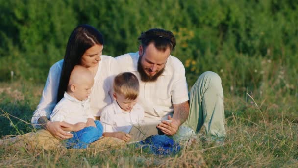 Junge Familie im Urlaub mit seinen beiden Söhnen. Video auf dem Tablet ansehen — Stockvideo