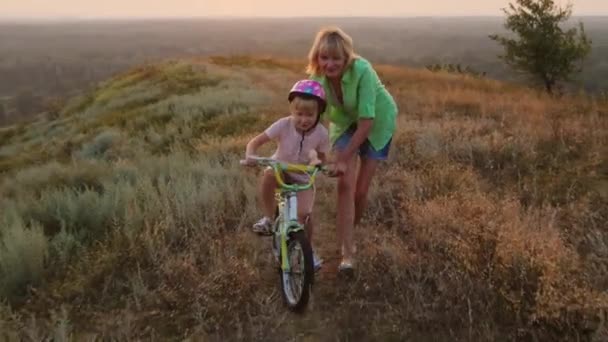 Az első gyermek dreams - anya lánya tanít lovagolni a kerékpár — Stock videók