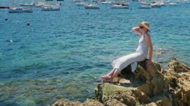 Vinç atış: kadın turist şapka ve güneş gözlüğü tekneler ve yatlar koy güzel manzaralarına hayran. Başlıklar için boş alan