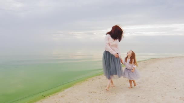 Steadicam geschoten: zorgeloos moeder en dochter drie jaar achtereen aan het strand — Stockvideo