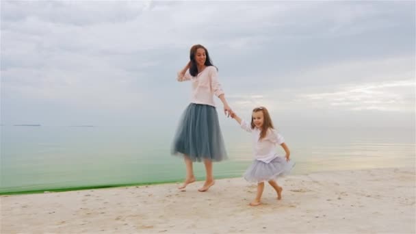 Madre e hija saltando diversión corriendo en la playa — Vídeo de stock