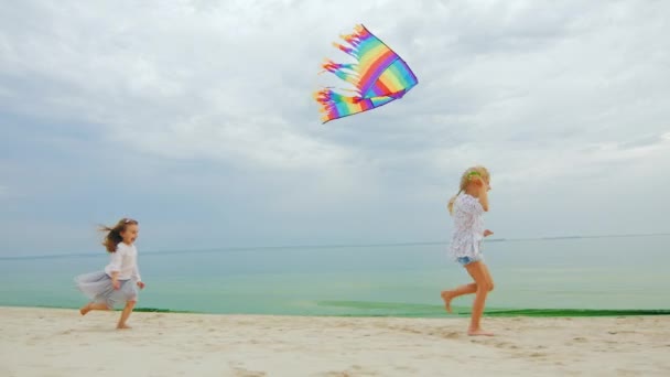 Duas meninas brincando na praia. Voando um papagaio — Vídeo de Stock
