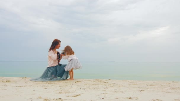 Joven madre un fotógrafo tratando de tomar una foto de su hija en la playa — Vídeos de Stock