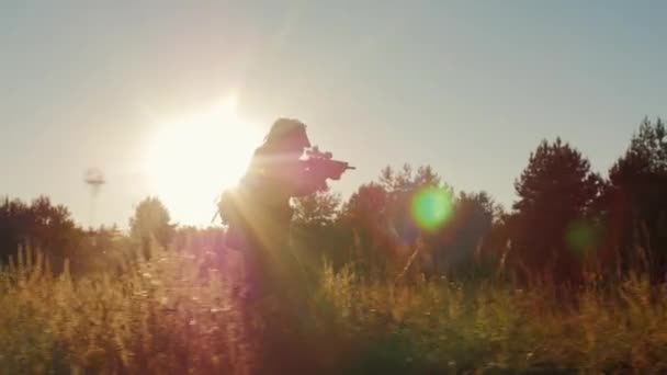 Steadicam lassított lövés: sziluettje fegyveres férfiak a támadást. Fut karokkal a nap — Stock videók