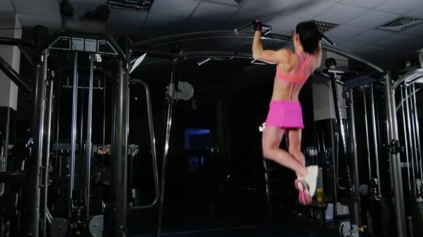Atractiva mujer fitness tira de la barra en el gimnasio. Culturismo femenino. Vista lateral — Vídeos de Stock