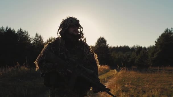 Steadicam çekim: gün batımında bir ülke yolda yürüyen bir adam ile silahlı — Stok video