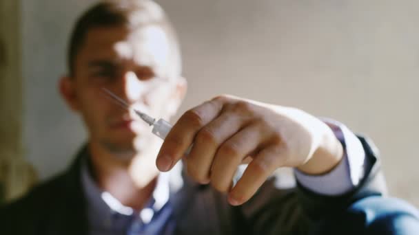 Un jeune homme tenant une seringue avec une drogue. Concept : la volonté d'arrêter la drogue, le danger, le crime — Video