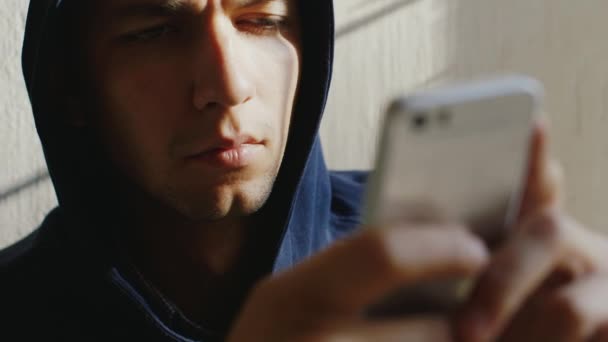 Un hombre muy cansado escribe un mensaje por teléfono. Está en el capó, sus ojos dormilones — Vídeo de stock