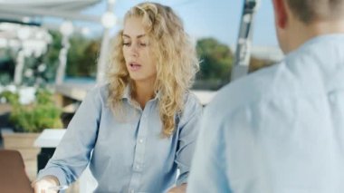 İş kadını bir müşteri veya ortak, bir sunum ile tanışır. Arkadan görülen ikinci muhatap