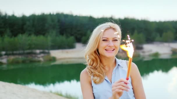 Loira atraente com fogos de artifício e sparkler na mão, para se divertir — Vídeo de Stock