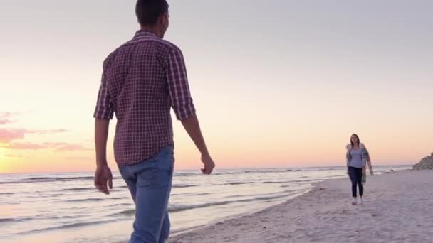 Молодая пара встретилась на пляже, обнимаясь — стоковое видео