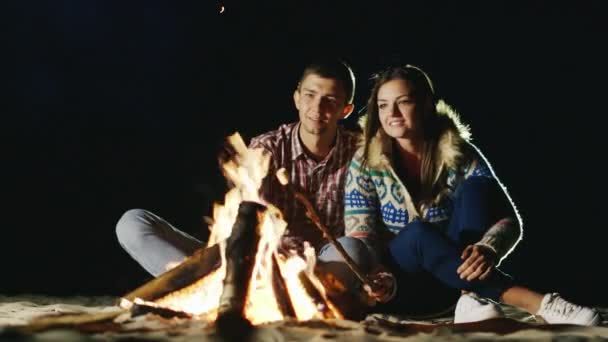 Due video: serata rilassante tra uomo e donna intorno al falò, arrosto di marshmallow in bastoncini di fuoco — Video Stock