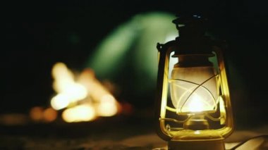 Bir yangın çadır kuma arka gaz lambası duruyor