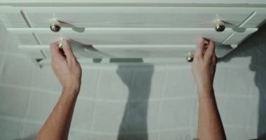 Adam çekmeceyi gömleklerle açıyor