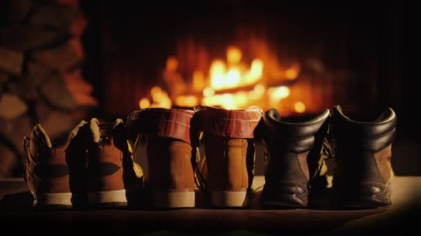 Los zapatos húmedos de invierno se secan junto a la chimenea. Descanse después de una caminata de invierno y la comodidad de un concepto de hogar cálido — Vídeos de Stock