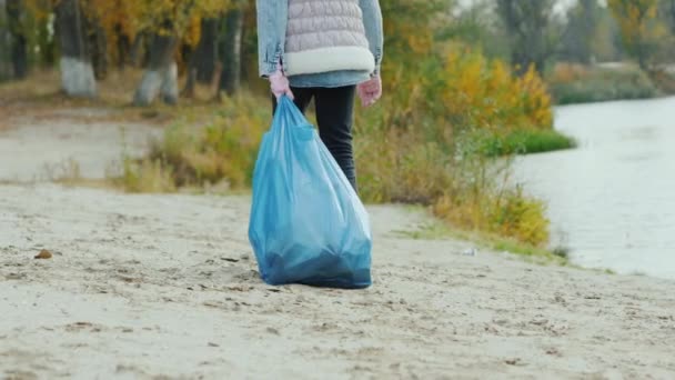 Kind draagt een zware tas met afval. Parkreiniging en milieuzorg — Stockvideo